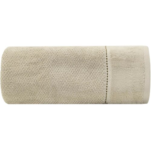 Beżowy ręcznik o wymiarach 50 x 90 cm, zwinięty w rolkę, z widocznym ozdobnym paskiem. Materiał ręcznika ma jednolitą teksturę frotte.