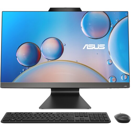 Na zdjęciu znajduje się komputer stacjonarny typu all-in-one z dużym ekranem, na którym widoczne są kolorowe bańki na niebieskim tle oraz logo "ASUS". Przed komputerem umieszczono czarną klawiaturę i myszkę.