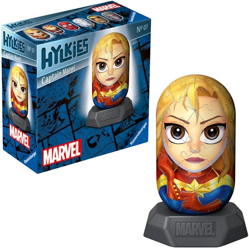 Pudełko z puzzlami 3D przedstawia postać z komiksów Marvela, z napisem "Hylkies Captain Marvel" oraz "Ravensburger" na niebieskim tle z komiksowymi grafikami. Obok pudełka znajduje się złożona figura z puzzli, przedstawiająca tę samą postać, umieszczona n