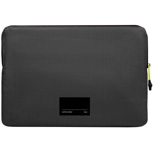 Czarne etui na laptopa z widocznym logo "NATIVE UNION Paris" na dole oraz żółtym suwakiem z boku. Powierzchnia etui ma delikatną, kratkowaną fakturę.
