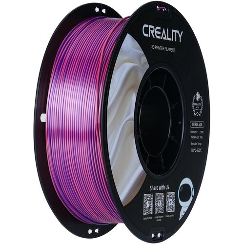 Zdjęcie przedstawia szpulę różowo-fioletowego filamentu do drukarki 3D, umieszczoną na czarnej podstawie z napisem "CREALITY 3D PRINTER FILAMENT". Na etykiecie widnieje tekst: "CR-PLA SILK, Diameter: 1.75MM, Net Weight: 1KG, Extruder Temp: 190°C-230°C", a