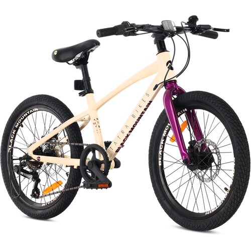 Kremowo-fioletowy rower dziecięcy z 20-calowymi kołami, posiadający napis "TATRA BIKES" na ramie oraz "BLACK MOUNTAIN" na oponach. Rower wyposażony jest w czarne siodełko, pedały oraz kierownicę z hamulcami tarczowymi.