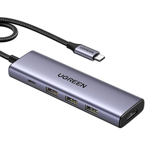 Na zdjęciu widoczny jest hub USB w kolorze srebrnym z czterema portami USB i jednym portem USB typu C, z napisem "UGREEN" na obudowie. Kabel z wtyczką USB typu C również ma napis "UGREEN".