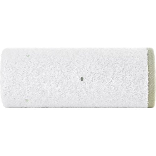 Zdjęcie przedstawia biały ręcznik o wymiarach 50 x 90 cm, zwinięty w rolkę. Na powierzchni ręcznika widoczne są drobne, ciemniejsze kropki.