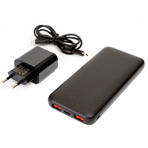 Na zdjęciu znajduje się czarny powerbank z dwoma czerwonymi portami USB oraz ładowarka z wtyczką i kablem USB. Na ładowarce widoczne są oznaczenia techniczne i certyfikaty.