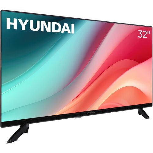 Telewizor z logo "HYUNDAI" w lewym górnym rogu i oznaczeniem "32''" w prawym górnym rogu, wyświetlający kolorowy gradient w odcieniach niebieskiego, różowego i czerwonego. Urządzenie stoi na dwóch czarnych nóżkach.