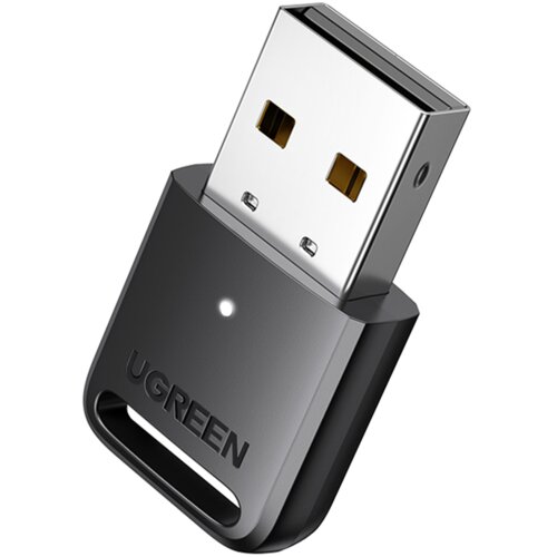 Na zdjęciu znajduje się czarny adapter USB z metalową wtyczką, na którym widnieje logo "UGREEN". Adapter ma małą, okrągłą diodę na obudowie.