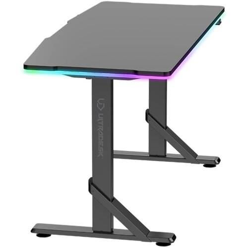 Czarne biurko gamingowe z podświetleniem RGB na krawędziach blatu, z solidnymi metalowymi nogami w kształcie litery "T". Na jednej z nóg widoczny jest napis "ULTRADESK".