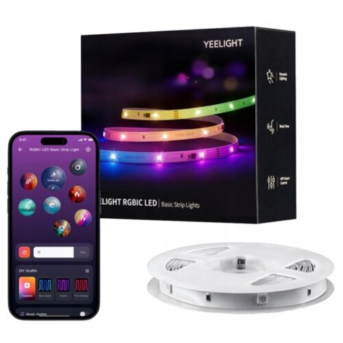 Na zdjęciu znajduje się opakowanie produktu "YEELIGHT RGBIC LED Basic Strip Lights" z kolorowymi taśmami LED oraz smartfon z aplikacją do sterowania oświetleniem. Obok widoczna jest zwinięta biała taśma LED.