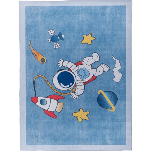 Na zdjęciu znajduje się niebieski dywan z motywem kosmicznym, przedstawiający astronautę, rakietę, planety, gwiazdy i satelitę. Elementy te są w jasnych kolorach, takich jak czerwony, żółty i biały, na tle jednolitego niebieskiego.