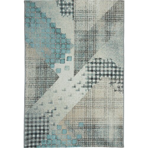 Dywan zewnętrzny o wymiarach 160 x 220 cm w kolorze turkusowym, z geometrycznym wzorem składającym się z kwadratów i kratki w różnych odcieniach turkusu, szarości i beżu. Wzór jest asymetryczny, z różnorodnymi teksturami i przejściami kolorystycznymi.