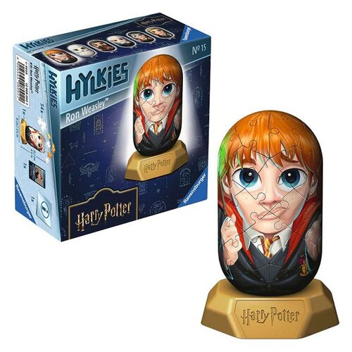 Na zdjęciu widoczny jest produkt "Puzzle 3D RAVENSBURGER Hylkies Harry Potter Ron Weasley 12008002 (54 elementy)" oraz jego opakowanie. Opakowanie jest niebieskie z grafiką przedstawiającą ułożone puzzle w kształcie postaci z dużymi oczami, a na nim widni