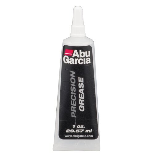 Przedstawiony jest biały pojemnik z wąską końcówką, na którym widnieje czarne tło z białym tekstem. Na etykiecie znajduje się napis: "Abu Garcia PRECISION GREASE 1 oz. 29.57 ml www.abugarcia.com".