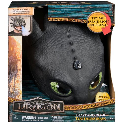 Czarna, interaktywna maska smoka z filmu "How to Train Your Dragon" z dużymi zielonymi oczami, umieszczona w opakowaniu z napisem "BLAST AND ROAR TOOTHLESS MASK". Na opakowaniu widnieje również napis "TRY ME! ESSAIE-MOI! PRUÉBAME!" oraz ostrzeżenie: "WARN