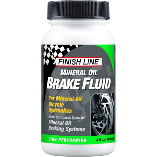 Biała butelka z czarną zakrętką, na której widnieje logo "FINISH LINE" oraz napis "MINERAL OIL BRAKE FLUID". Na etykiecie znajduje się również tekst: "For Mineral Oil Bicycle Hydraulics" oraz zdjęcie tarczy hamulcowej, a na dole napis "HIGH PERFORMING 4 fl oz / 120 ml".