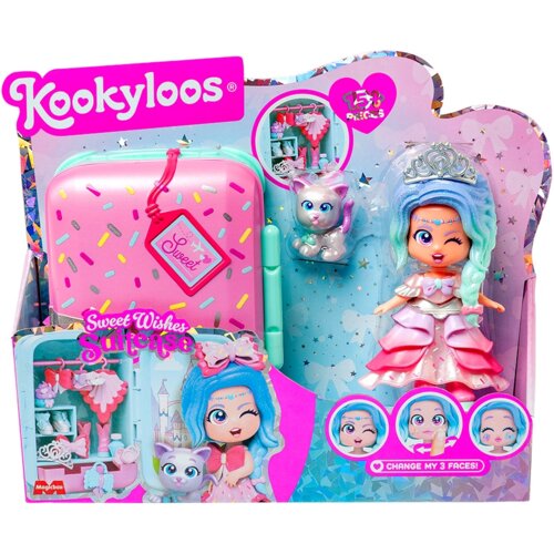 Opakowanie produktu "Lalka MAGIC BOX Kookyloos Suitcases Sweet Wishes PKLSP104IN310" przedstawia różową walizkę z kolorowymi wzorami, srebrnego kotka oraz lalkę w różowo-białej sukience z niebieskimi włosami i tiarą. Na opakowaniu widnieją napisy: "Kookyl