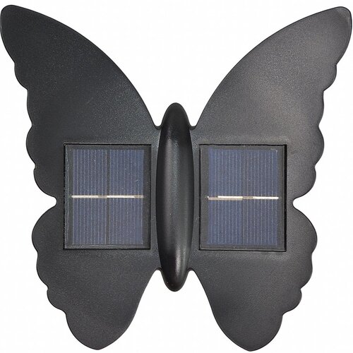 Czarna lampa solarna w kształcie motyla z dwoma panelami słonecznymi umieszczonymi symetrycznie na skrzydłach. Skrzydła mają faliste krawędzie, a całość wykonana jest z matowego materiału.