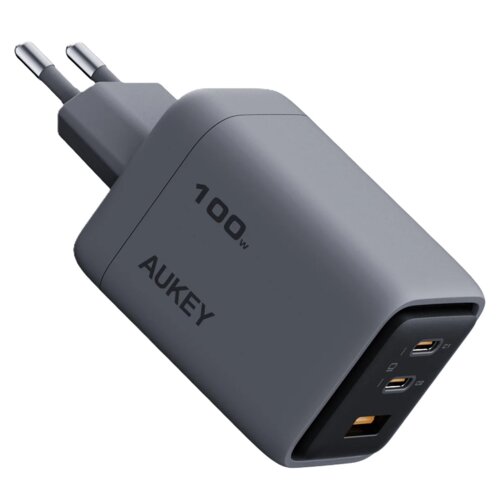 Szara ładowarka sieciowa z dwoma portami USB-C i jednym portem USB-A, z widocznymi napisami "100W" oraz "AUKEY" na obudowie. Wtyczka jest typu europejskiego z dwoma bolcami.