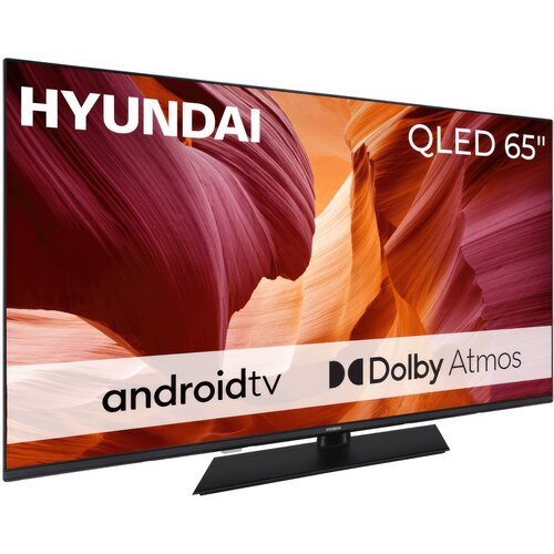 Telewizor marki HYUNDAI z ekranem QLED o przekątnej 65 cali, na którym widoczne są napisy: "android tv" oraz "Dolby Atmos". Tło ekranu przedstawia abstrakcyjne, kolorowe wzory w odcieniach czerwieni i pomarańczu.