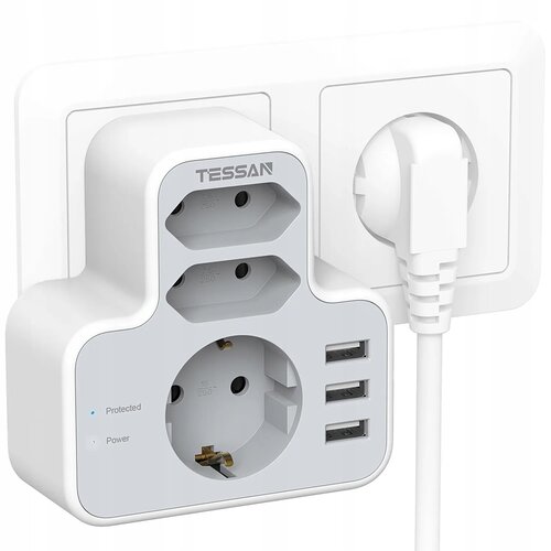 Biała listwa zasilająca z logo "TESSAN" posiada trzy gniazda elektryczne oraz trzy porty USB, a także wskaźniki "Protected" i "Power". Listwa jest podłączona do gniazdka ściennego, obok którego znajduje się wtyczka z białym kablem.