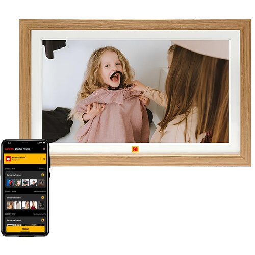 Na zdjęciu widoczna jest cyfrowa ramka w drewnianej oprawie z wyświetlonym zdjęciem dwóch dzieci, z logo KODAK na dole. Obok ramki znajduje się smartfon z aplikacją "KODAK Digital Frame", pokazującą listę zdjęć i statusy ich przesyłania.