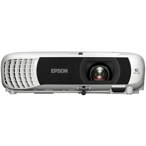 Projektor w kolorze białym z czarnym panelem frontowym, na którym znajduje się logo "EPSON" oraz obiektyw. Po prawej stronie widoczne jest logo "3LCD".