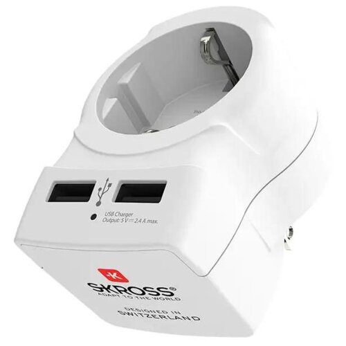 Biały adapter podróżny z dwoma portami USB i gniazdem elektrycznym, z widocznym napisem "SKROSS ADAPT TO THE WORLD" oraz "DESIGNED IN SWITZERLAND". Na urządzeniu znajduje się również informacja o wyjściu USB: "Output: 5V - 2.4A max".