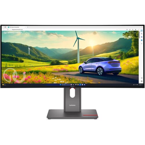 Monitor marki Lenovo wyświetla obraz przedstawiający krajobraz z samochodem na drodze, otoczonym polami i wiatrakami na tle gór. Na ekranie widoczna jest strona internetowa "The Green Connection", a na podstawie monitora znajduje się logo Lenovo.