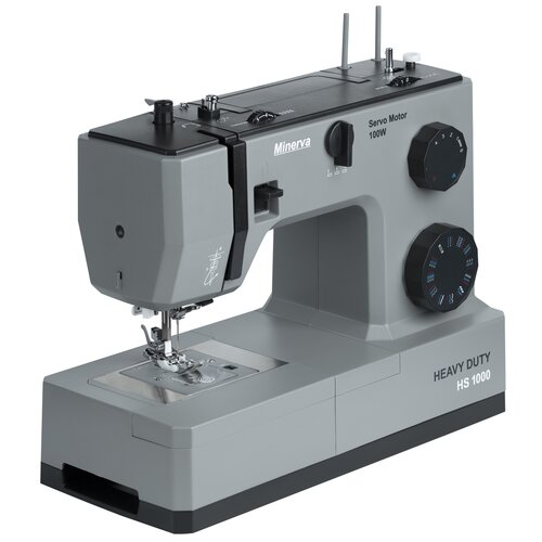 Szara maszyna do szycia z napisem "Minerva" oraz "Servo Motor 100W" na obudowie, posiada dwa pokrętła z oznaczeniami ściegów i napis "HEAVY DUTY HS 1000" na podstawie. Na maszynie widoczny jest również schematyczny rysunek igły i nici.