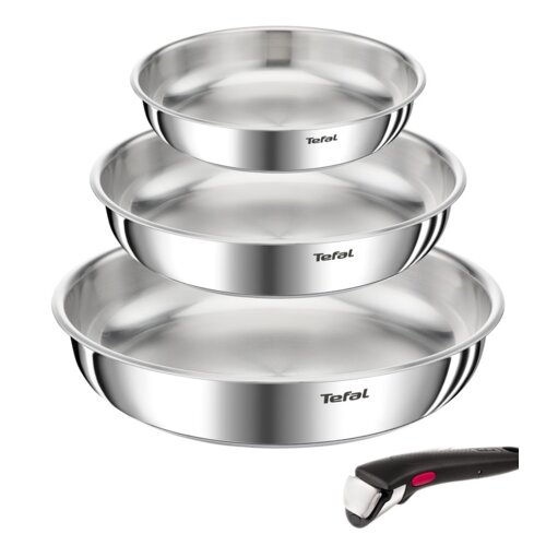 Na zdjęciu widoczne są trzy metalowe patelnie ułożone jedna na drugiej, każda z logo "Tefal" na boku, oraz odłączany uchwyt z czarnym wykończeniem i czerwonym przyciskiem. Patelnie mają błyszczącą powierzchnię, a uchwyt jest umieszczony obok nich.