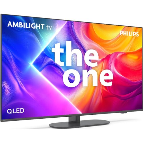 Telewizor z kolorowym ekranem wyświetlającym abstrakcyjne wzory w odcieniach fioletu, niebieskiego, pomarańczowego i czerwonego, z widocznymi napisami: "AMBILIGHT tv", "PHILIPS", "the one" oraz "QLED". Telewizor stoi na prostokątnej podstawie.