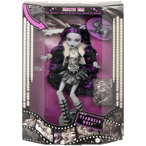 Pudełko zawiera lalkę z serii Monster High, ubraną w strój z futrzanym kołnierzem i spódniczką, z długimi, ciemnymi włosami z fioletowymi pasemkami. Na opakowaniu widnieje tekst: "Monster High Reel Drama - Drama de Película - Drame au Cinéma" oraz "Admit 