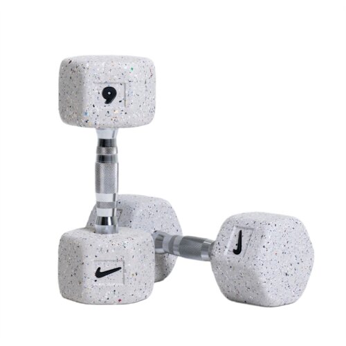 Na zdjęciu widoczne są dwie szare hantle z kolorowymi kropkami, każda o masie 6 kg, z metalowym uchwytem. Na hantlach znajduje się logo Nike.