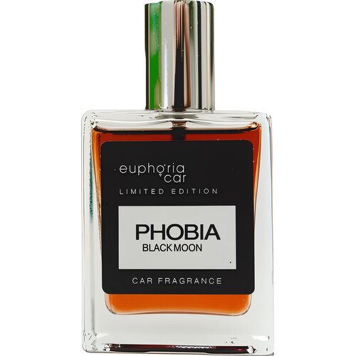Prostokątna butelka z przezroczystego szkła zawiera pomarańczowy płyn, a na jej froncie znajduje się czarna etykieta z białym napisem: "euphoria car LIMITED EDITION PHOBIA BLACK MOON CAR FRAGRANCE". Srebrna zakrętka odbija światło, dodając elegancji całem