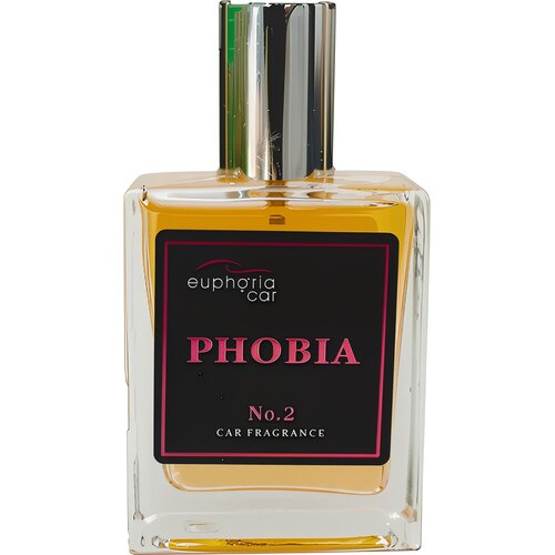 Przedstawione zdjęcie ukazuje prostokątną butelkę perfum z przezroczystego szkła, wypełnioną żółtawym płynem. Na czarnej etykiecie widnieje tekst: "euphoria car PHOBIA No. 2 CAR FRAGRANCE".