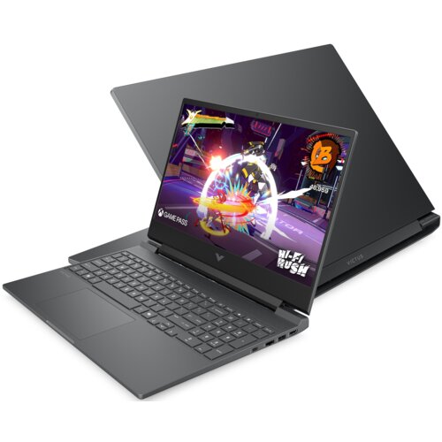 Na zdjęciu widoczny jest otwarty laptop z wyświetlaczem pokazującym kolorową grę wideo, na którym znajduje się napis "GAME PASS" oraz "HI-FI RUSH". Obok laptopa znajduje się jego zamknięta pokrywa z napisem "VICTUS".