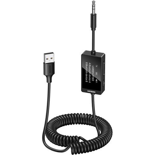 Na zdjęciu znajduje się czarny transmiter UGREEN BT303 z wyświetlaczem, na którym widnieje tekst: "UGREEN BT303 A.Bluetooth device A B.Bluetooth device B". Urządzenie jest połączone z kablem USB, a jego przewód jest spiralnie zwinięty.