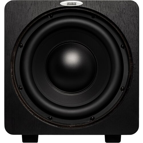 Czarny subwoofer z widocznym dużym głośnikiem centralnym, otoczony ciemną obudową o drewnianej fakturze. Na górze obudowy znajduje się logo z napisem "velodyne".