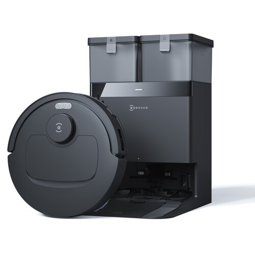 Czarny robot sprzątający z widocznym logo "ECOVACS" na stacji dokującej, obok której znajduje się okrągły odkurzacz z trzema przyciskami na górze. Stacja dokująca ma dwa pojemniki na górze i jest w kolorze czarnym.