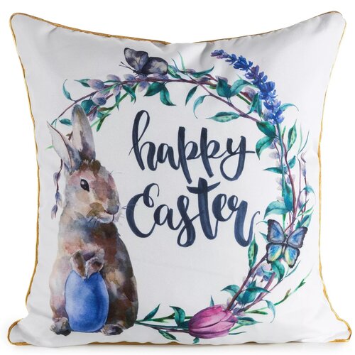 Biała poszewka z nadrukiem przedstawiającym królika trzymającego niebieskie jajko, otoczonego wieńcem z kwiatów i liści, z napisem "happy Easter". Krawędzie poszewki są obszyte złotą lamówką.