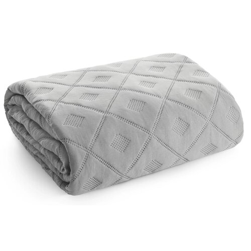 Srebrna narzuta o wymiarach 170 x 210 cm, z widocznym wzorem w romby, złożona w prostokątny kształt. Materiał ma delikatną teksturę z perforowanymi detalami w środku każdego rombu.