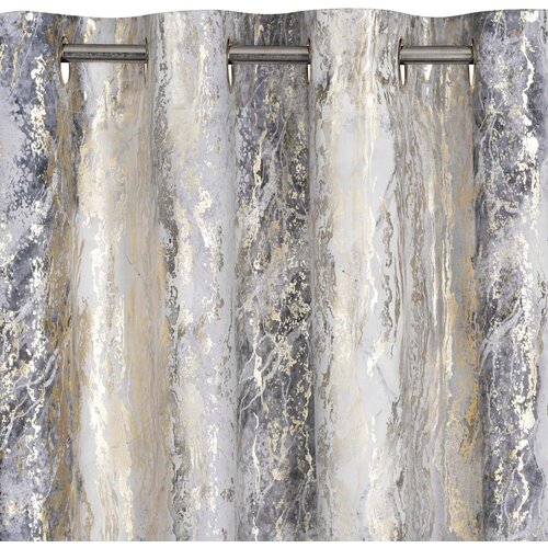 Zasłona o wymiarach 135 x 250 cm w kolorze srebrno-szampańskim z abstrakcyjnym wzorem, zawieszona na metalowym karniszu. Materiał ma teksturę przypominającą marmur z odcieniami szarości, srebra i złota.