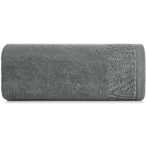 Szary ręcznik o wymiarach 50 x 90 cm, zwinięty w rolkę, z widoczną teksturą materiału i ozdobnym wzorem na jednym z końców. Produkt nie posiada widocznych napisów ani logo.