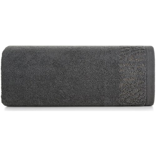 Szary ręcznik o wymiarach 70 x 140 cm, zwinięty w rolkę, z widocznym delikatnym wzorem na jednym z końców. Materiał wygląda na miękki i puszysty.
