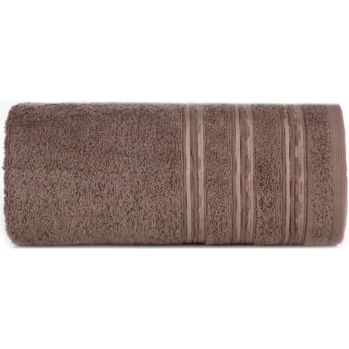 Brązowy ręcznik o wymiarach 50 x 90 cm, zwinięty w rolkę, z widocznymi trzema ozdobnymi paskami wzdłuż jednego z boków. Materiał ręcznika ma teksturę frotte.