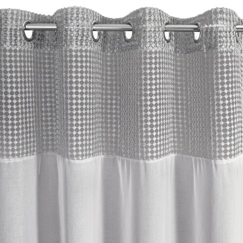 Szara firana o wymiarach 135 x 250 cm z górną częścią ozdobioną wzorem w kropki, wykonana z materiału o delikatnej fakturze. Firana posiada metalowe przelotki umożliwiające łatwe zawieszenie na karniszu.