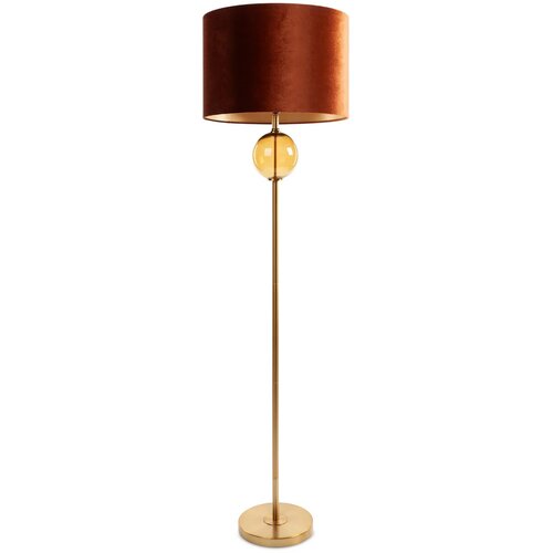 Lampa podłogowa z okrągłym, ceglasto-złotym abażurem i złotą podstawą, ozdobiona szklaną kulą w połowie wysokości. Produkt ma smukłą konstrukcję i stoi na okrągłej podstawie.