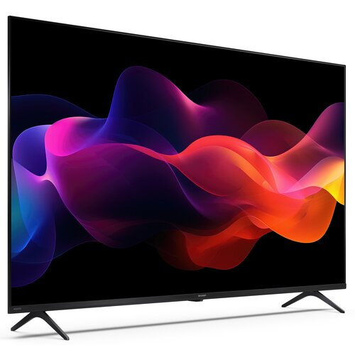 Na zdjęciu widoczny jest telewizor z cienką ramką, wyświetlający kolorową grafikę z falami w odcieniach fioletu, różu, pomarańczu i czerwieni na czarnym tle. Na dolnej ramce telewizora znajduje się logo "SHARP".