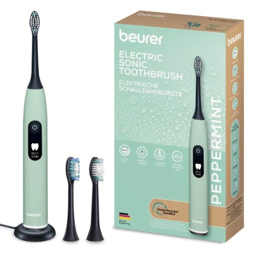 Soniczna szczoteczka do zębów w miętowym kolorze stoi na podstawce obok dwóch wymiennych końcówek, a obok znajduje się pudełko z napisem "beurer ELECTRIC SONIC TOOTHBRUSH ELEKTRISCHE SCHALLZAHNBÜRSTE" oraz "PEPPERMINT". Na pudełku widoczne są ikony przeds