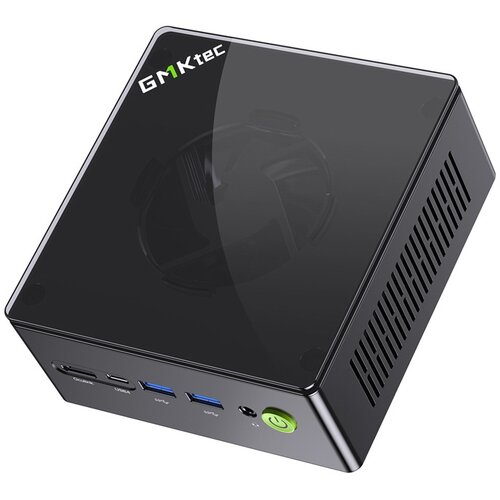 Czarny, kompaktowy komputer z widocznym logo "GMKtec" na górnej powierzchni. Na przednim panelu znajdują się różne porty, w tym USB i przycisk zasilania z zielonym symbolem.